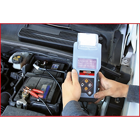 Ein Techniker hält ein Batterietestgerät in der Hand und testet die Batterie eines Autos.